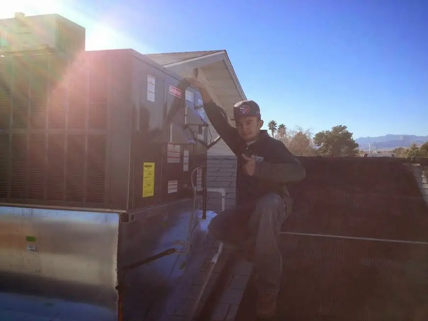 HVAC technician performing Air Duct Cleaning on a rooftop unit in Elkton