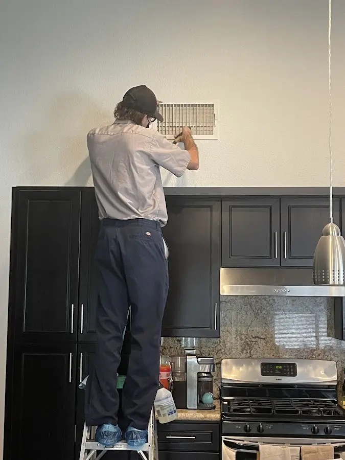 Technician inspecting an air vent during HVAC service in Elkton